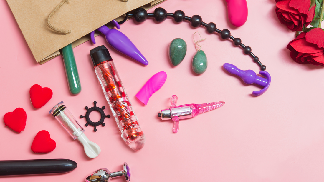 A selection of sex toys made from different materials on a pink table