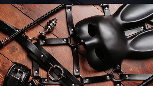 BDSM Gear with bunny mask, Black Leather BDSM whip and restraints on wooden table