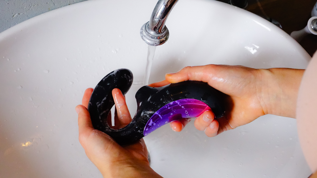Image of someone cleaning adult toys under water