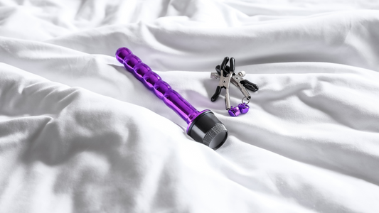Purple BDSM product and two purple nipple clamps on a white sheet