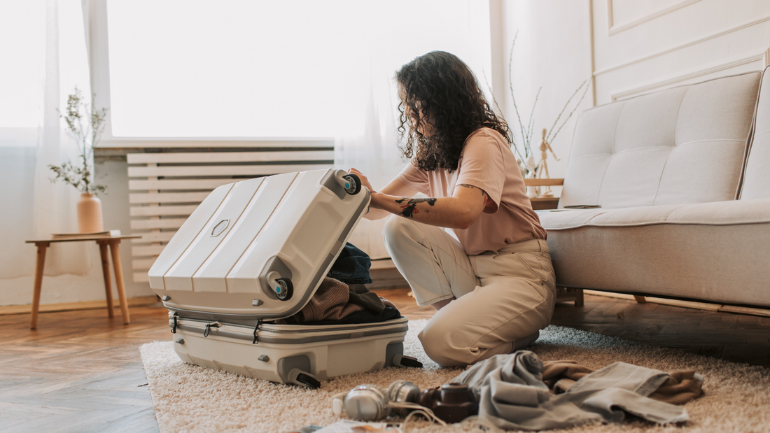 Woman sat on floor packing sex toys in a brown suitcase